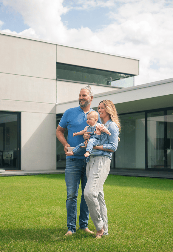 family-of-three-standing-in-garden-of-their-home-2024-09-22-11-05-53-utc